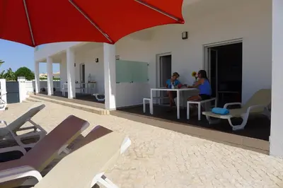 two women sitting at a table on a patio at Apartamento Villa Bellevue vista mar in Albufeira