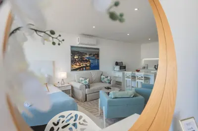 a mirror reflecting a living room and a kitchen at Estúdios Marina in Vilamoura