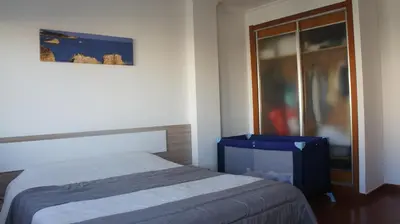 a bedroom with a bed and a sliding glass door at Pool & Garden Oura Albufeira Flat in Albufeira