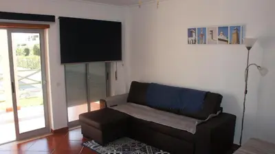 a living room with a couch and a television at Pool & Garden Oura Albufeira Flat in Albufeira
