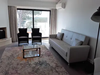 a living room with a couch and two chairs at Victory Village Club in Quinta do Lago