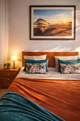 a bedroom with a bed with a painting on the wall at Fisherman´s beach apartment in Albufeira