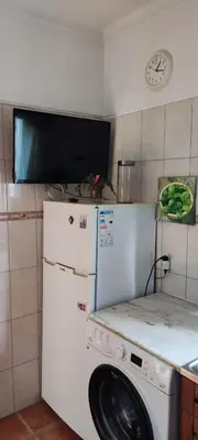 a kitchen with a washing machine and a tv at Fisherman´s beach apartment in Albufeira