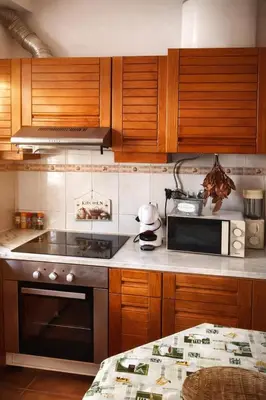 a kitchen with wooden cabinets and a stove top oven at Fisherman´s beach apartment in Albufeira