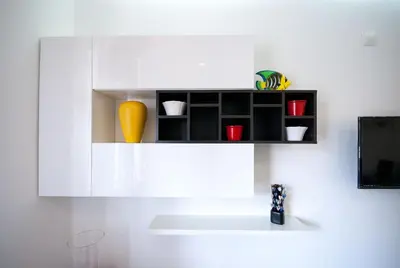 a white shelf with red cups and a yellow vase at Old Town Sant'ana T2 in Albufeira