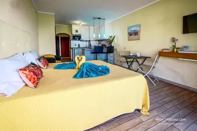 a bedroom with a large yellow bed with towels on it at Estrela do Mar in Albufeira