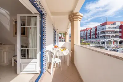 a balcony with a table and a view of buildings at Apartamento Praia da Oura in Albufeira