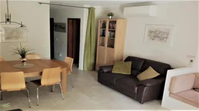 a living room with a table and a couch at Casa Esperança in Albufeira