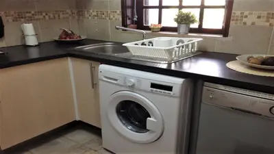 a kitchen with a washing machine and a sink at Casa Esperança in Albufeira