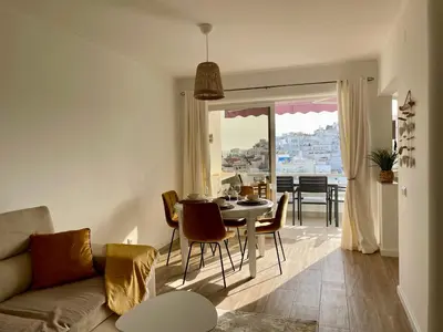 a living room with a couch and a table with chairs at RosaMar apartment sea view and pool in Albufeira