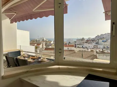 a window with a view of a city from a balcony at RosaMar apartment sea view and pool in Albufeira