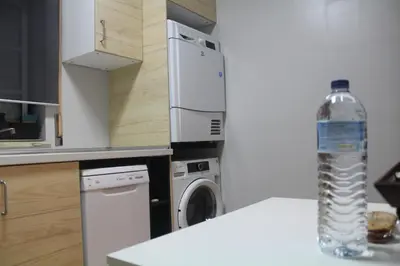 a bottle of water sitting on a counter next to a washing machine at Apartamento Lara in Albufeira