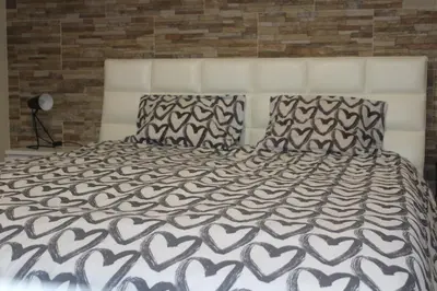 a bedroom with a white bed with two pillows at Apartamento Lara in Albufeira