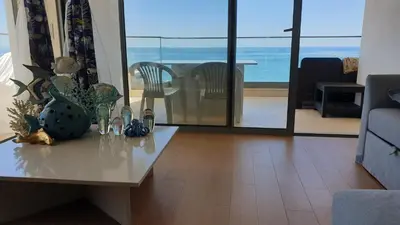 a living room with a table with a view of the ocean at ocean blue in Quarteira