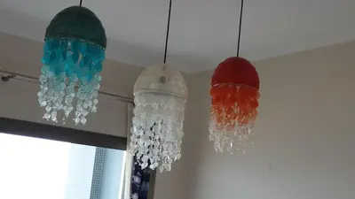 three glass chandeliers hanging from a ceiling at ocean blue in Quarteira