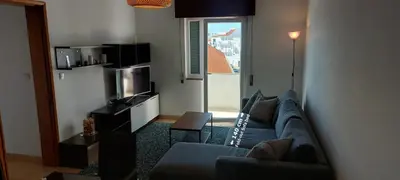 a living room with a blue couch and a television at KAP Sea View Balcony in Albufeira