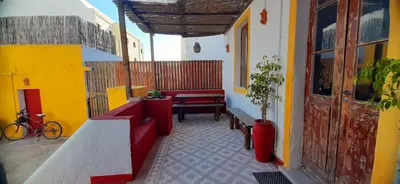 a balcony of a building with a table and a bench at Hostel A Casa da Árvore in Faro