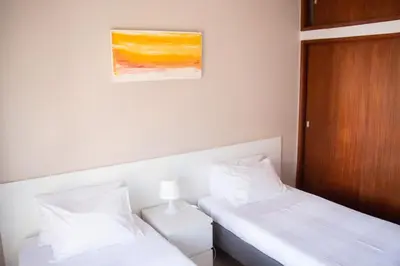 a bedroom with a dresser and a mirror and a chair at Apartamentos Central in Quarteira