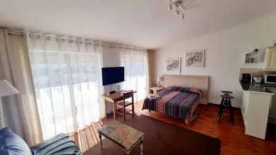 a hotel room with a bed and a living room at Musa Mar studio with balcony panoramic view in the residential area in Quarteira