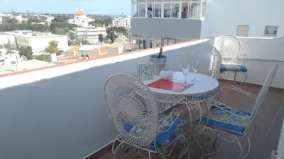 a living room with a couch and a television at Musa Mar studio with balcony panoramic view in the residential area in Quarteira