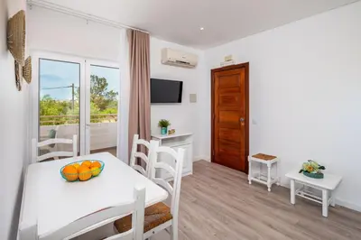a dining room with a table and chairs and a window at Apartamentos Flor da Laranja, Albufeira by AlgarveBlossom in Albufeira