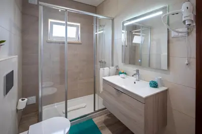 a bathroom with a shower and a sink and a toilet at Apartamentos Flor da Laranja, Albufeira by AlgarveBlossom in Albufeira