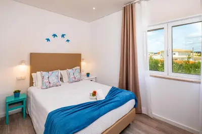 a bedroom with a bed and a window at Apartamentos Flor da Laranja, Albufeira by AlgarveBlossom in Albufeira