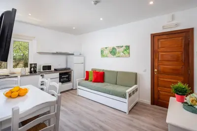 a kitchen and living room with a couch and a table at Apartamentos Flor da Laranja, Albufeira by AlgarveBlossom in Albufeira