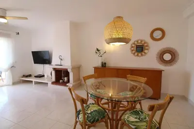 a dining room with a glass table and chairs at Beauty by the Sea in Albufeira