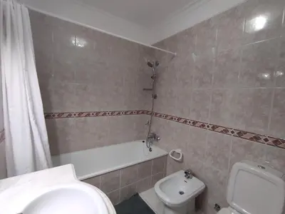 a bathroom with a toilet and a tub and a sink at Beauty by the Sea in Albufeira