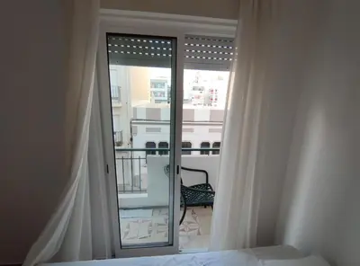 a bedroom with a window with a view of a balcony at Casa da avó Bia in Faro