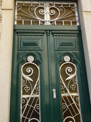 a green door with a wrought iron gate at Casa da avó Bia in Faro
