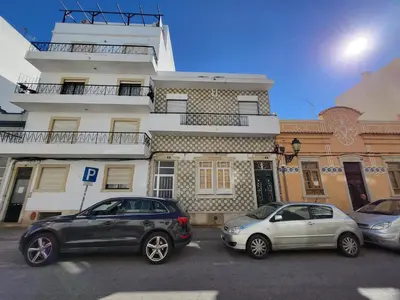 two cars parked in a parking lot in front of a building at Casa da avó Bia in Faro