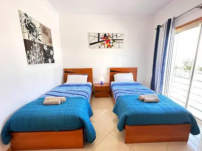two beds in a room with a window at Modern Ocean, Garden & Pool view Condo by BeCherish in Albufeira