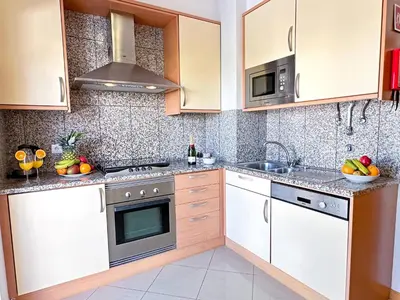 a kitchen with white cabinets and a sink at Modern Ocean, Garden & Pool view Condo by BeCherish in Albufeira