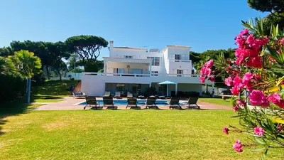 a large white building with chairs and flowers at Fonte Santa by Check-in Portugal in Quarteira