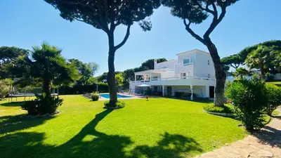 a large white house with palm trees in front of it at Fonte Santa by Check-in Portugal in Quarteira