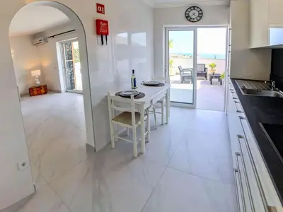 a kitchen and dining room with a table and chairs at Casa beira mar Algarve in Albufeira