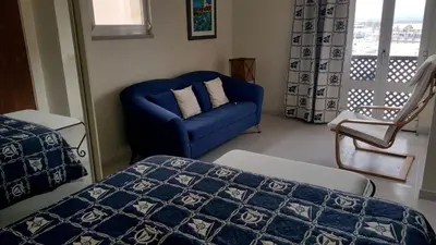 a bedroom with a blue bed and a blue chair at Marina Apartment in Quarteira