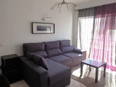 a living room with a blue couch and a table at Austral Apartment in Quarteira