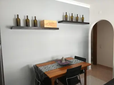 a dining room with a table with wine bottles on the wall at Austral Apartment in Quarteira