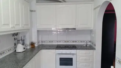 a kitchen with white cabinets and a stove top oven at Austral Apartment in Quarteira