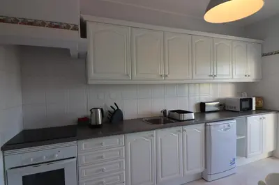 a white kitchen with white cabinets and a sink at APARTAMENTO MICÁ in Albufeira