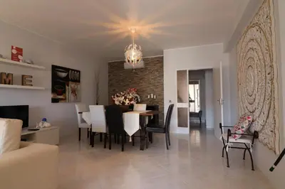 a dining room and living room with a table and chairs at APARTAMENTO MICÁ in Albufeira