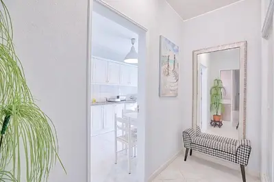 a hallway with a mirror and a chair in a kitchen at APARTAMENTO MICÁ in Albufeira