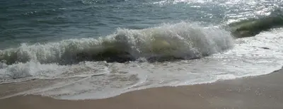 a small wave in the ocean on the beach at APARTAMENTO MICÁ in Albufeira