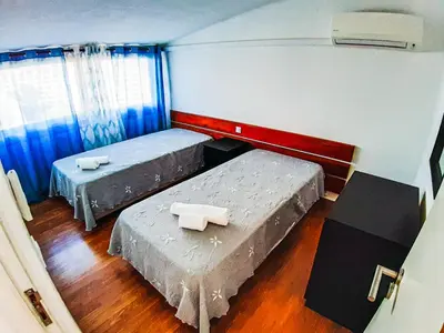 two beds in a room with blue curtains at Vilamagna Apartment 501 - By Algarkasa in Albufeira