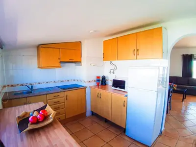 a kitchen with wooden cabinets and a bowl of fruit on a table at Vilamagna Apartment 501 - By Algarkasa in Albufeira