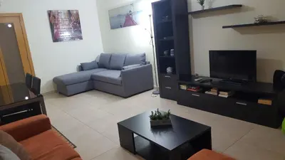 a living room with a couch and a tv at Plaza 305 Albufeira in Albufeira