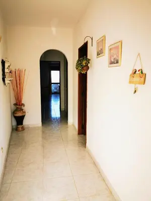a hallway with a white wall and a tile floor at Vista Mar 2 in Albufeira